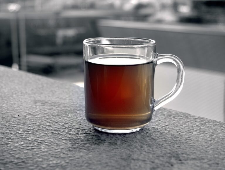 Tazza di tè rooibos rosso con foglie e antiossidanti, ideale per una bevanda senza teina.