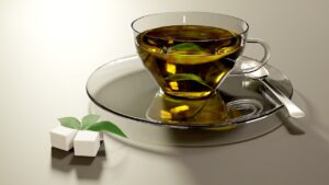 Immagine di una tazza di tè verde con foglie di tè e un simbolo di avvertimento sullo sfondo.