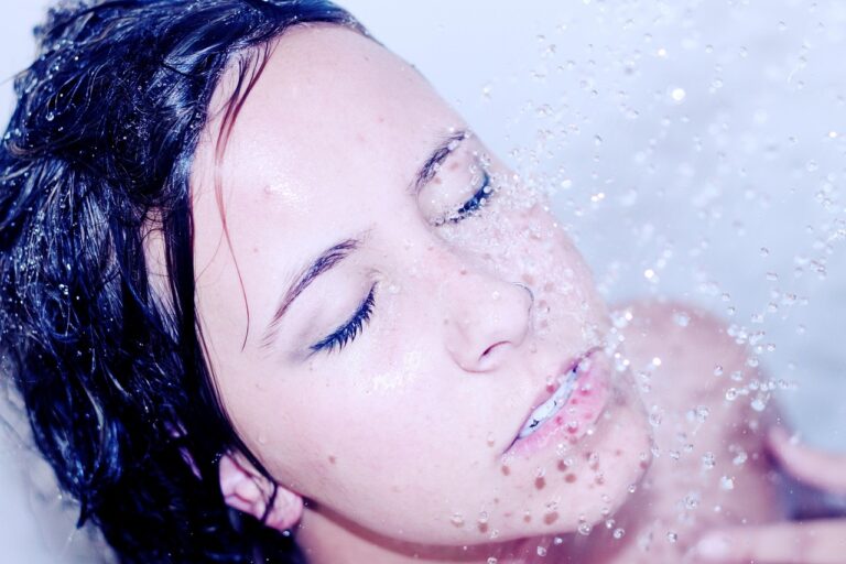 Donna che si sciacqua il viso dopo aver utilizzato acqua micellare.